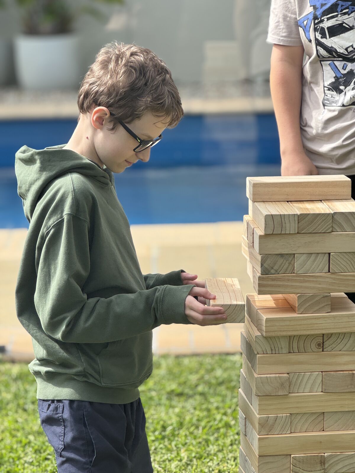 Giant wooden Jenga tower being played outdoors